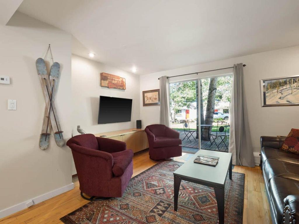 Relaxing 2 Bedroom steps from Vail Resort في فيل: غرفة معيشة مع أريكة وكراسي وتلفزيون