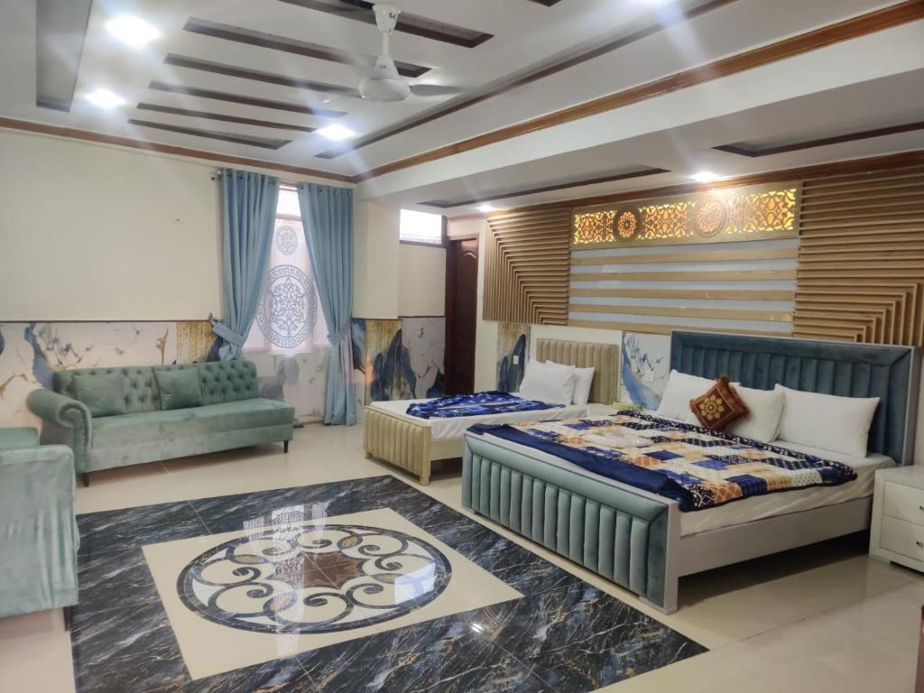 a bedroom with two beds and a couch at Al Wasay Hotel in Rawalpindi