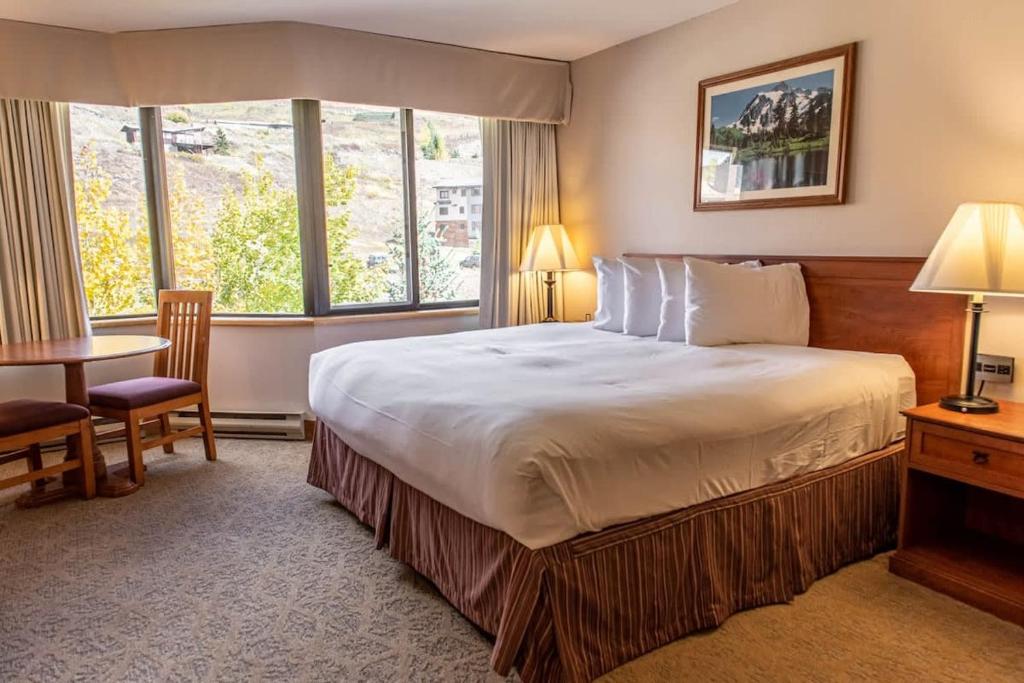 a hotel room with a large bed and a desk at Studio 521 Perfect Location with Pool and Hot Tub in Crested Butte
