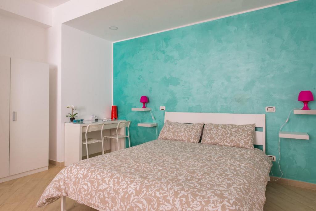 ein Schlafzimmer mit einem Bett und einer blauen Wand in der Unterkunft Talè Gioiosa in Gioiosa Marea