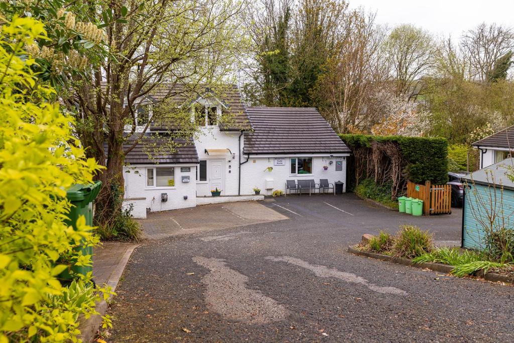 a white house with a parking lot at Roger Ground Guest House - with Onsite Car Parking in Windermere