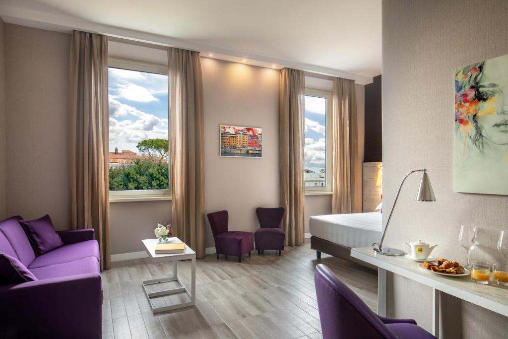 une chambre d'hôtel avec un lit et un canapé violet dans l'établissement The Guardian, à Rome