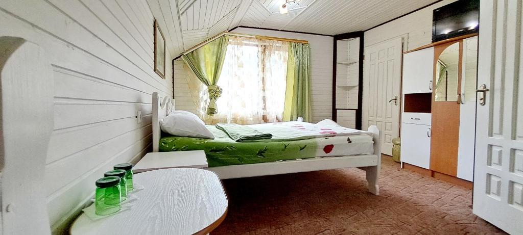 a small room with a bed and a table at Villa Girska Sonata in Mykulychyn