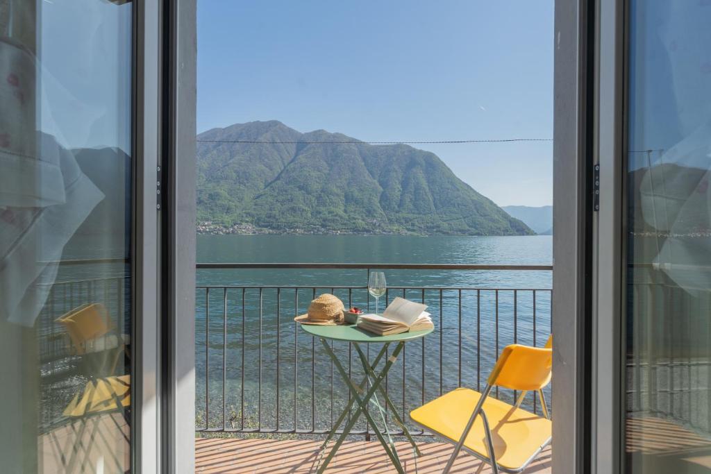 a room with a balcony with a view of the water at Il Timone by Rent All Como in Colonno