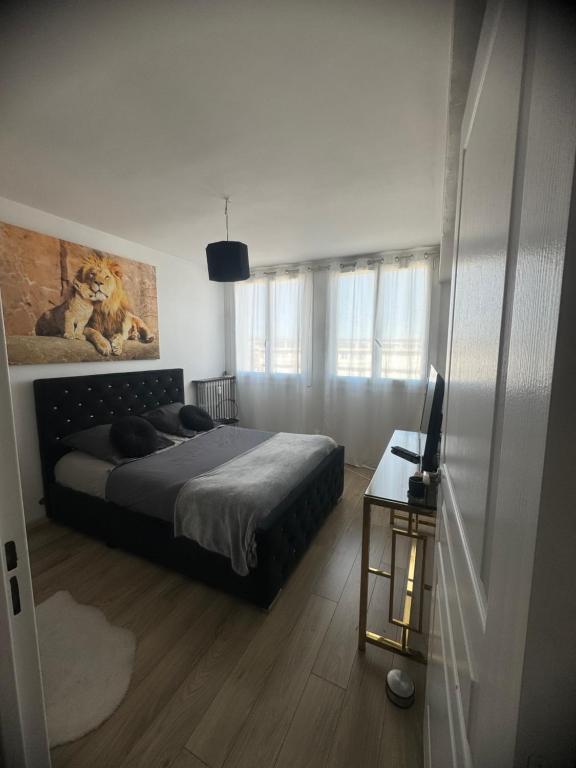 a bedroom with a bed and a table with a television at Appartement proche aéroport in Marignane