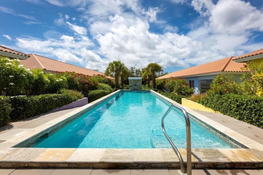 una piscina en un patio con una casa en Sunny Apartment Blije Rust, en Dorp Sint Michiel