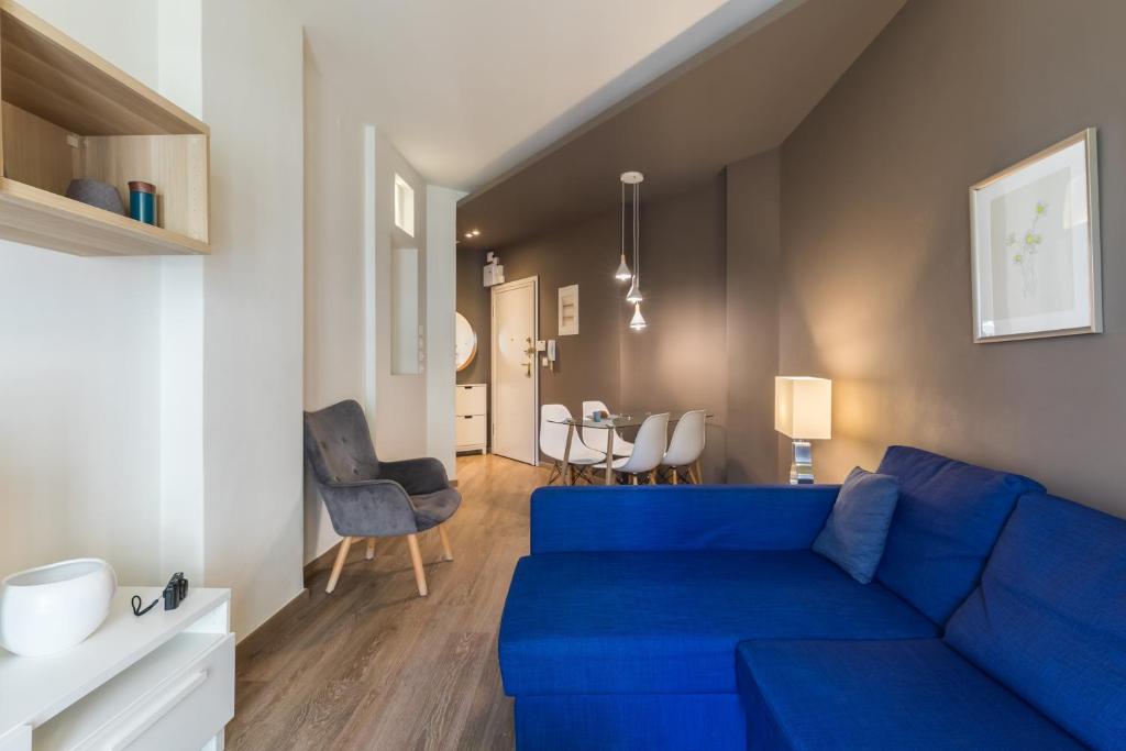 uma sala de estar com um sofá azul e uma sala de jantar em #Danae Apt by halu! Apartments em Tessalónica
