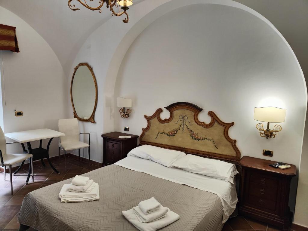 een slaapkamer met een bed met twee handdoeken erop bij Androsa Apartments in Amalfi