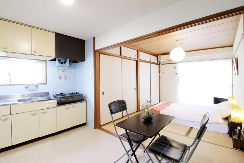 広島市にあるDai3Himawari by b hotel - Best location ! 1 min walk to Peace Park Dome -701の部屋にテーブルと椅子のあるキッチン