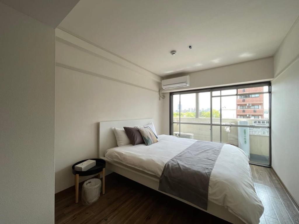 広島市にあるbHOTEL Dai3Himawari - 2BR good for 6PPL overlooking Peace Park with WIFI!のベッドルーム1室(ベッド1台、大きな窓付)