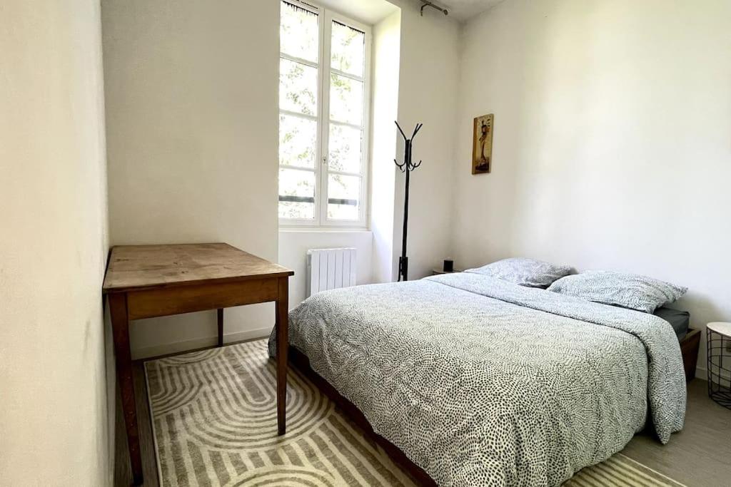- une chambre avec un lit, une table et une fenêtre dans l'établissement Le Manoir Mermoz : Appartement T2 tout équipé, à Rennes
