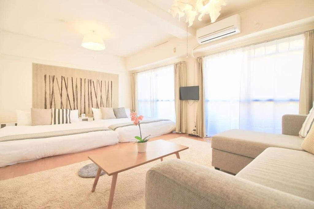 een woonkamer met twee witte banken en een tafel bij Earls Court - Capacious & Relaxing just 4 blocks to Peace Park in Hiroshima