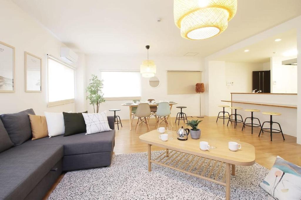 a living room with a couch and a table at Marumasa by b hotel - Large 2BR Apt 10PPL near Peace Park 301 in Hiroshima