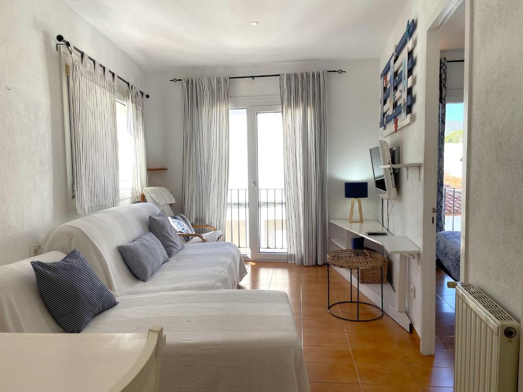 sala de estar con sofá blanco y algunas ventanas en CREUS - Apartment in the center of town, en Cadaqués