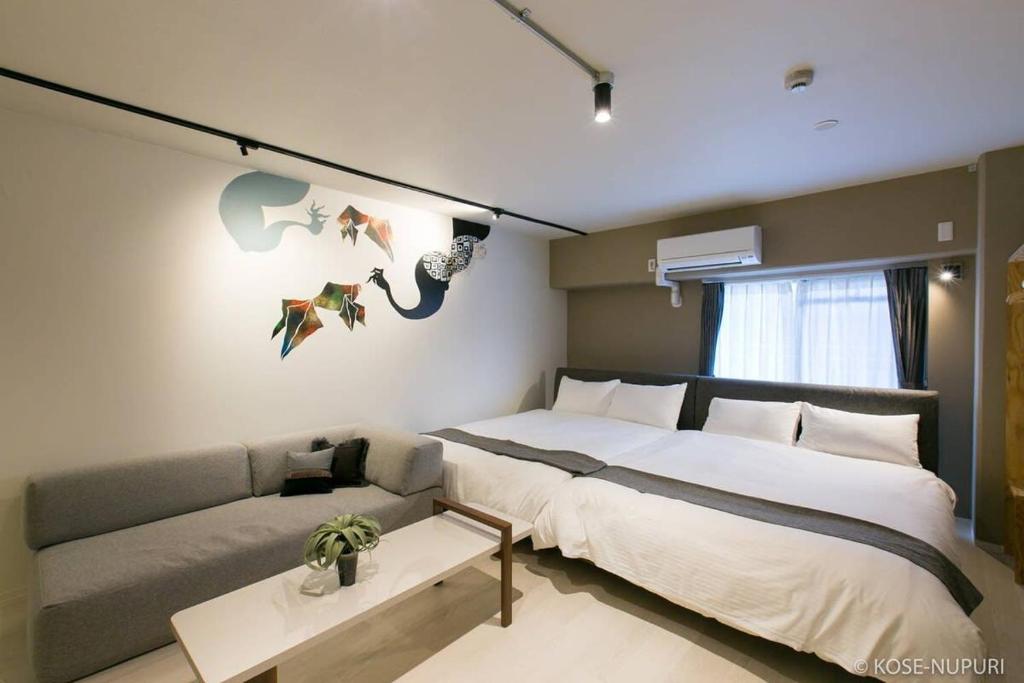 - une chambre avec un grand lit et un canapé dans l'établissement bHOTEL Origaminn 402 - 5 mins PeacePark, à Hiroshima