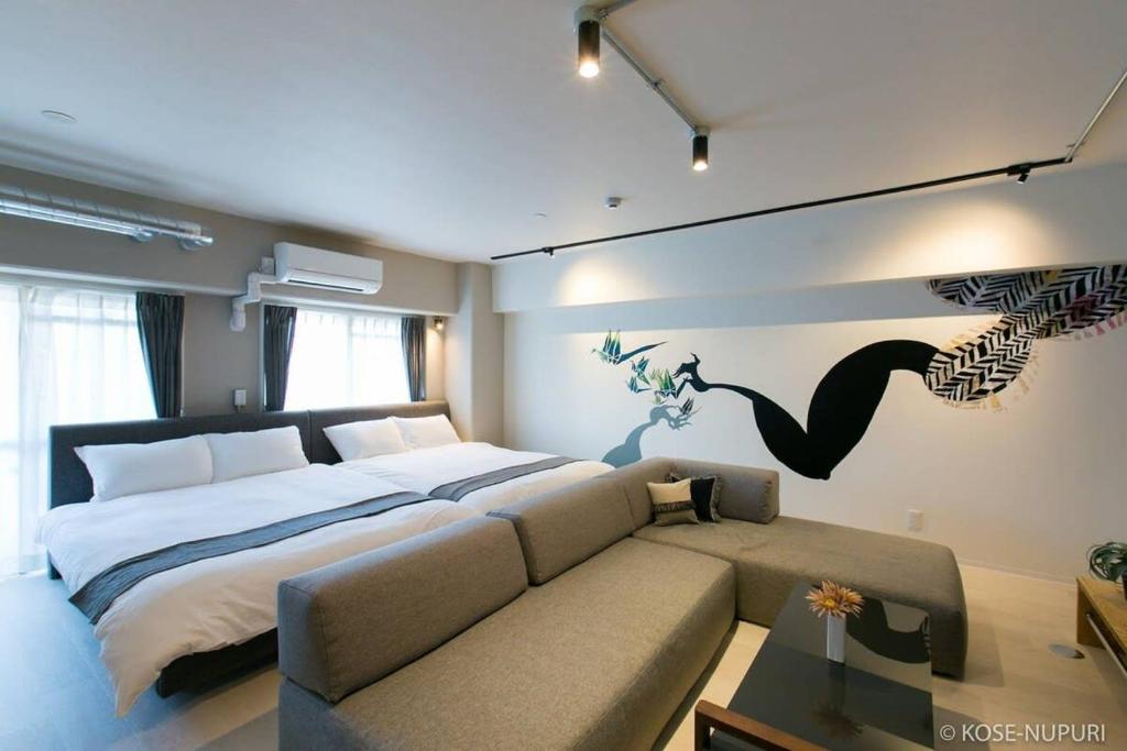 a bedroom with a large bed and a couch at bHOTEL Origaminn 301 - 5 mins Peace Park in Hiroshima