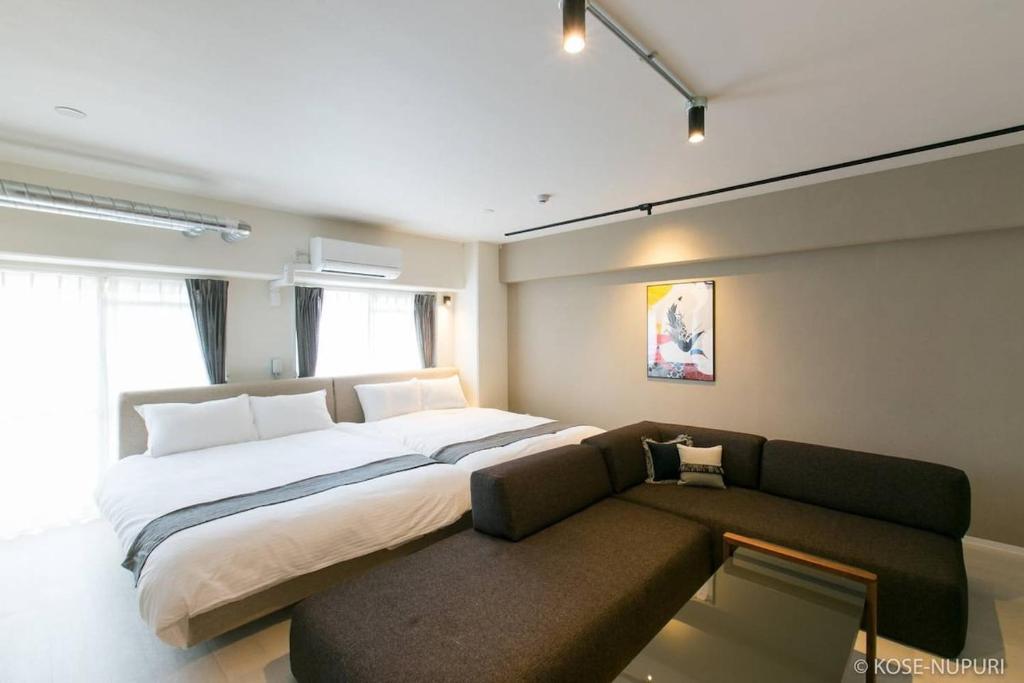 a bedroom with a large bed and a couch at bHOTEL Origaminn 501 - 5 mins PeacePark in Hiroshima