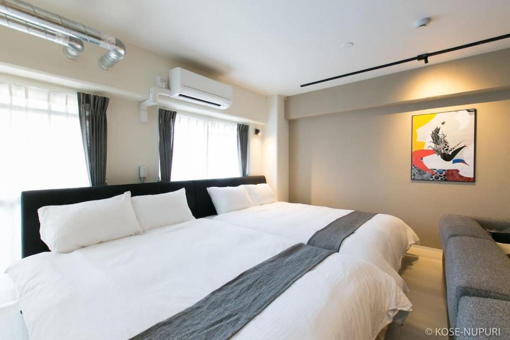 a bedroom with a large white bed and a couch at bHOTEL Origaminn 601 - 5 mins PeacePark in Hiroshima