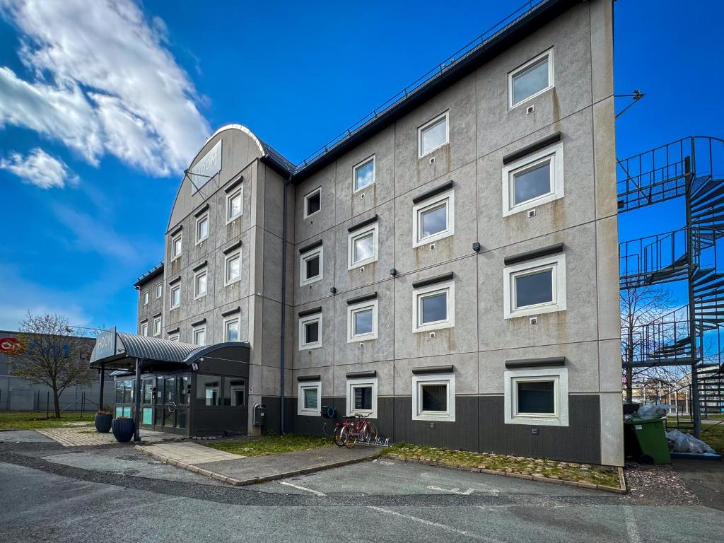 a building with a bus stop in front of it at HOOM Home & Hotel Jönköping in Jönköping