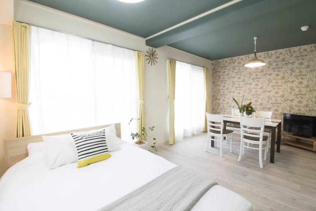 a bedroom with a bed and a dining room with a table at bHOTEL La-Shante - 5 mins walk to the PeacePark & Up to 4 ppl in Hiroshima