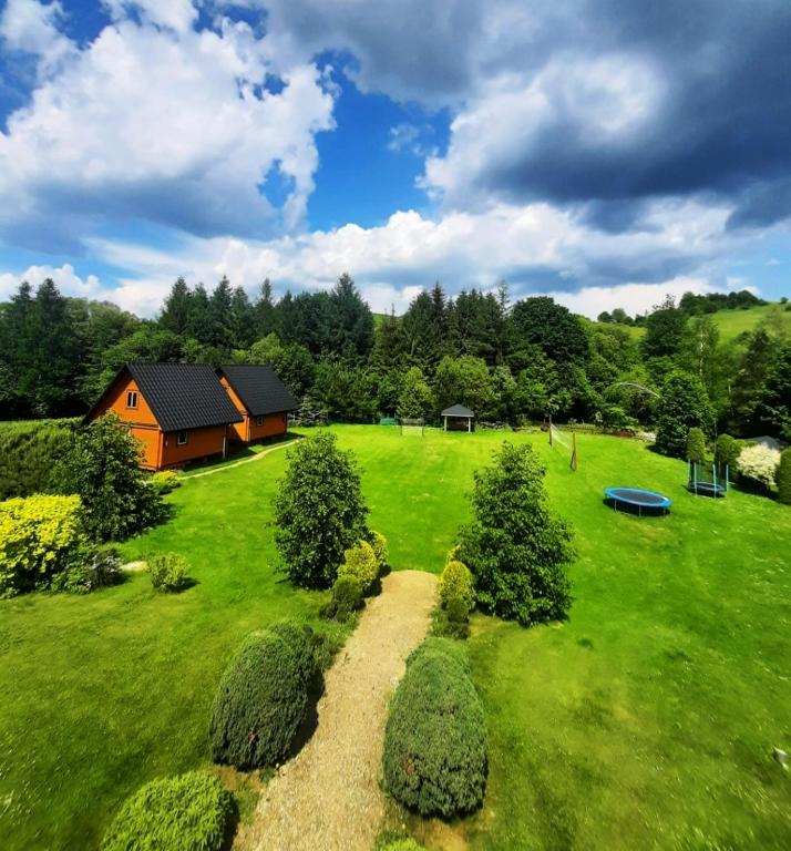a large green yard with a house and a frisbee at Bieszczady Domek Letniskowy in Polańczyk