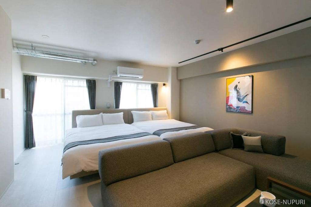 a bedroom with a large bed and a couch at bHOTEL Origaminn 701 - 5 mins PeacePark in Hiroshima