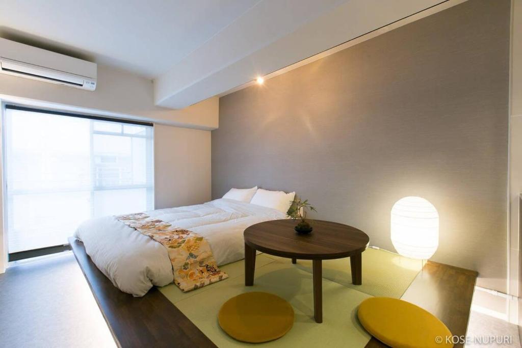 a bedroom with a large bed and a table at bHOTEL Origaminn 703 - 5 mins PeacePark in Hiroshima