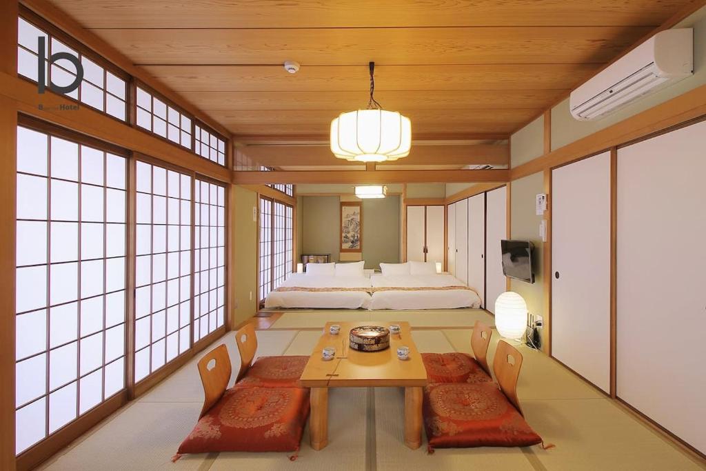 Habitación con cama, mesa y sillas. en Hanagin - 3 Bedroom Japanese apartment for 11 people 201, en Hiroshima