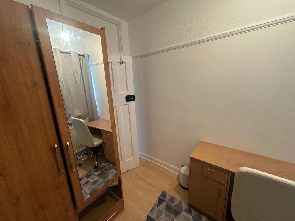 La petite salle de bains est pourvue d'un miroir et d'un lavabo. dans l'établissement Queenel Room, à Eltham