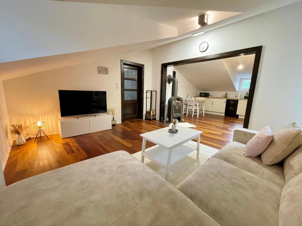 ein Wohnzimmer mit einem Sofa und einem Flachbild-TV in der Unterkunft Gemütliche 3-Zimmer Doppelhaushälfte mit Kamin und Parklatz, Nähe Ostsee Strand in Glücksburg