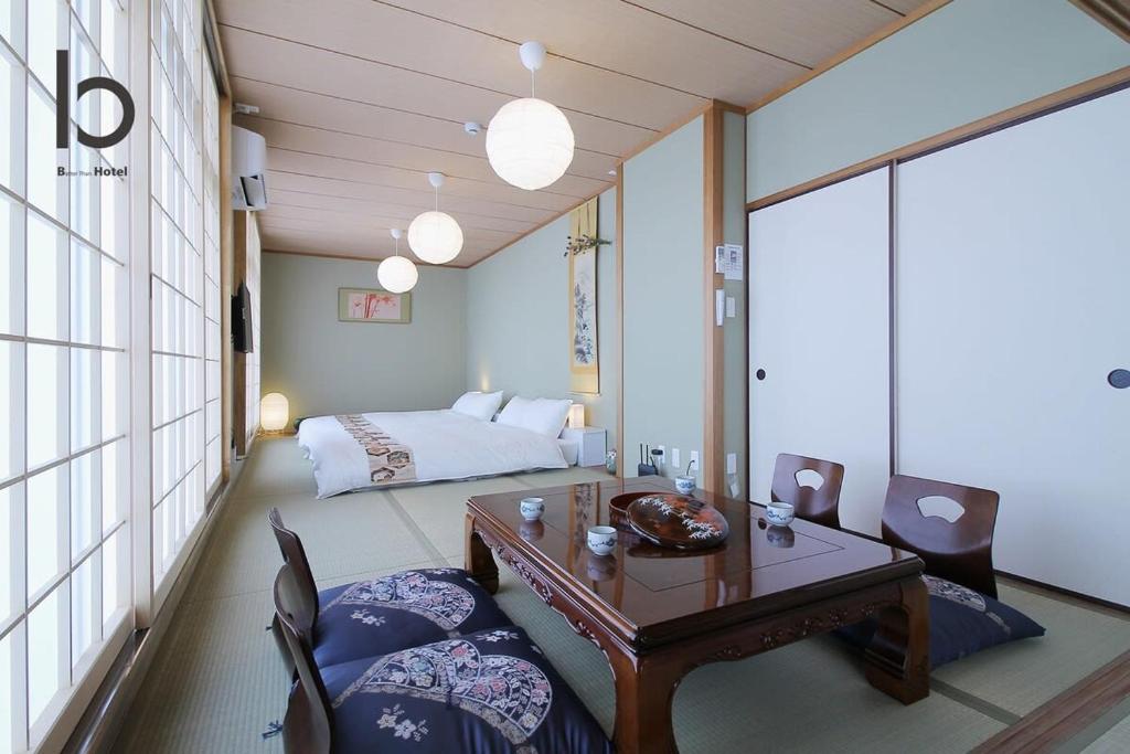 um quarto com uma cama, uma mesa e cadeiras em Hanagin - Spacious 2 bedroom Japanese Apt for 10 ppl 401 em Hiroshima