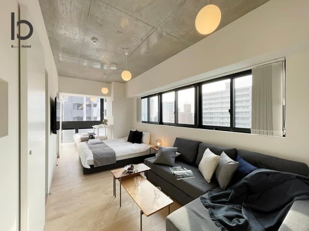 広島市にあるbHOTEL Nekoyard - New Modern Beautiful 1 BR Apartment, Very Near Peace Park, for 6Pplのリビングルーム(ソファ、ベッド付)