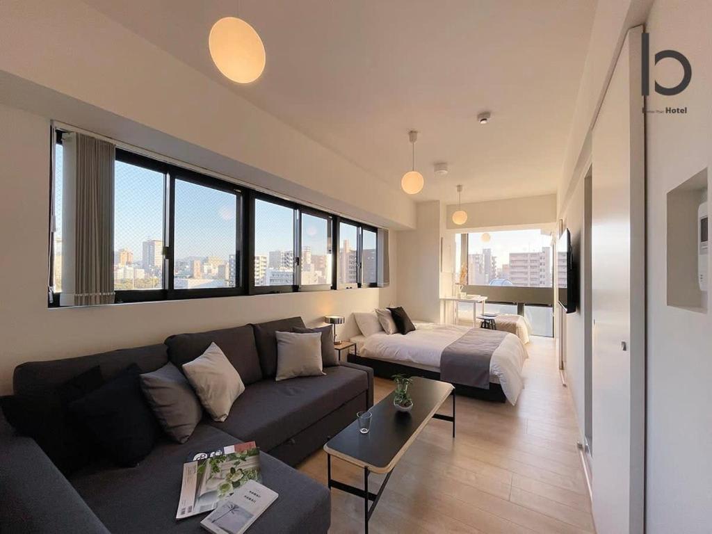 a living room with a couch and a bed at b hotel Nekoyard - Comfortable Studio, Easy Walk to Peace Park in Hiroshima