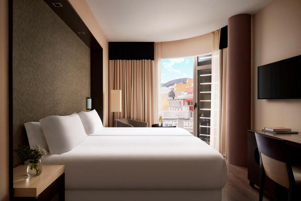 a hotel room with a large bed and a window at NH Tenerife in Santa Cruz de Tenerife