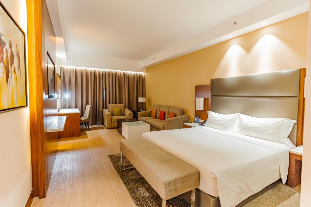 a hotel room with a bed and a living room at Crowne Plaza Nairobi Airport by IHG in Nairobi