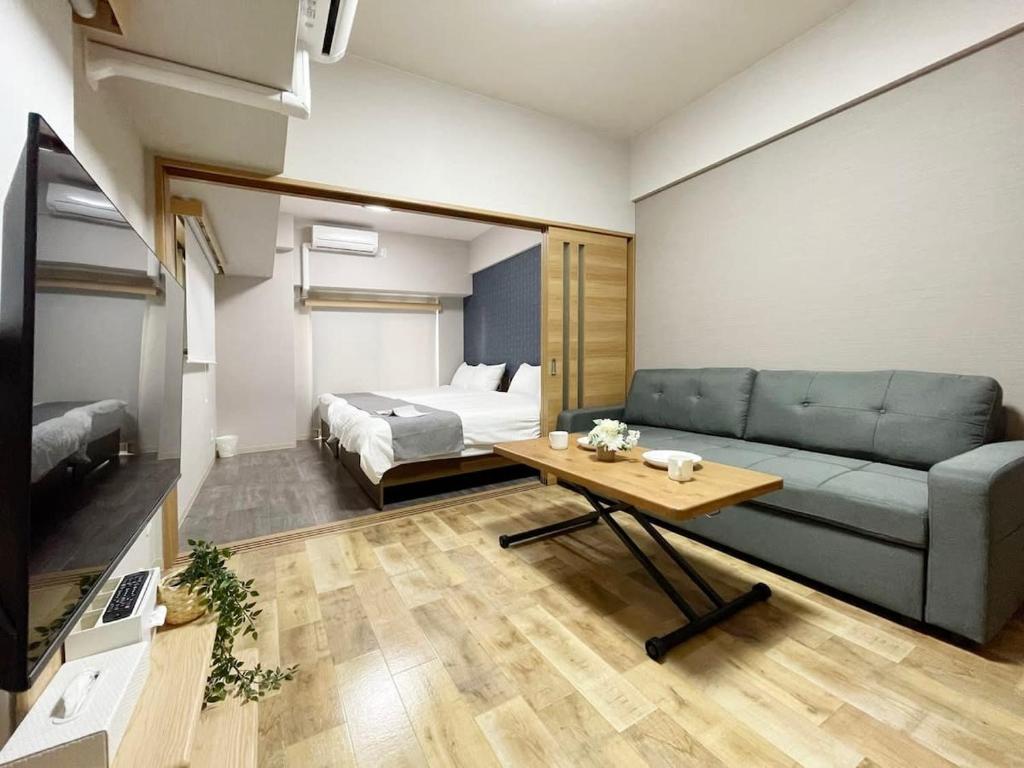 uma sala de estar com um sofá e uma cama em bHOTEL Casaen - 1BR with balcony near Hondori Shopping Arcade, 6PPL em Hiroshima