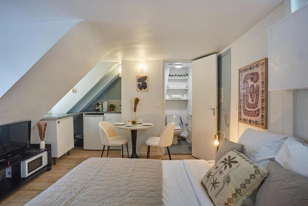 une chambre avec un lit et une table avec des chaises dans l'établissement Studio Place Vendome by Studio prestige, à Paris
