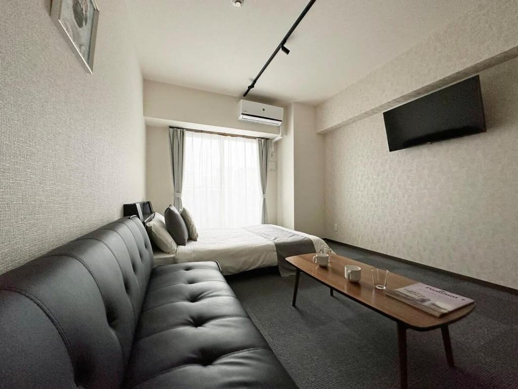廣島的住宿－bHOTEL Nagomi - Comfy Apartment for 3 people near City Center，客厅配有沙发和1张床
