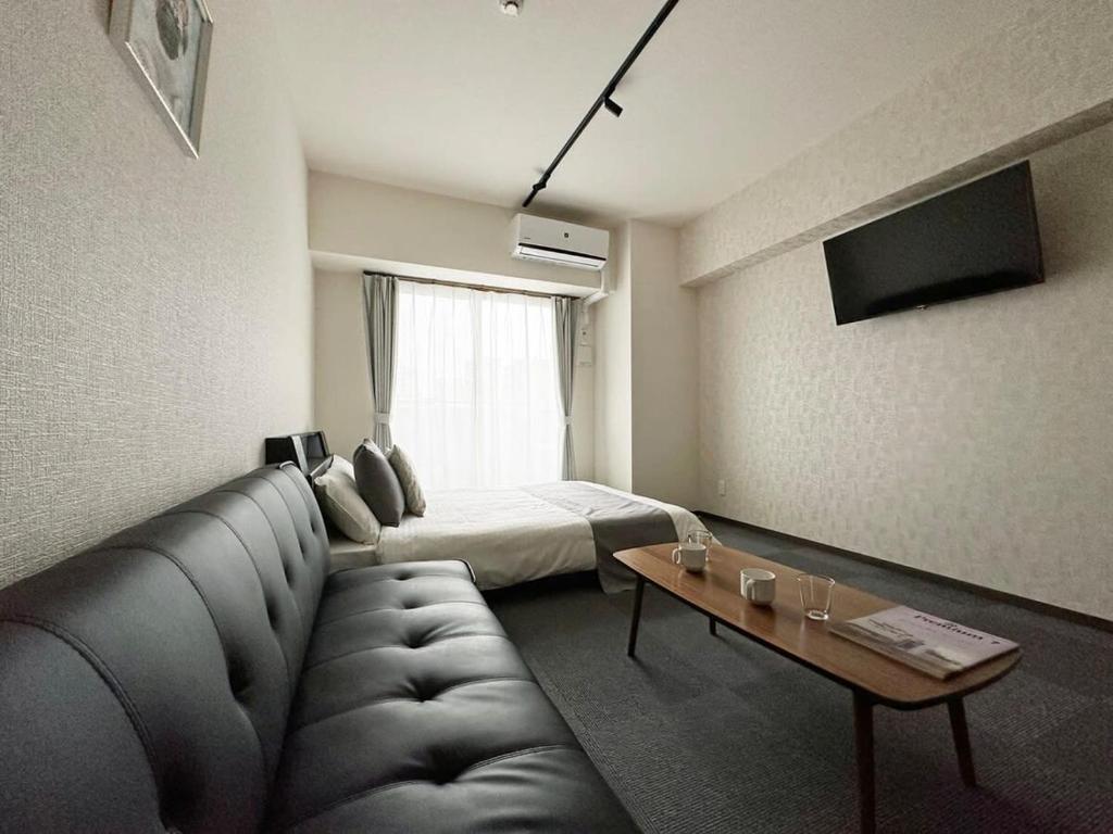 广岛Nagomi by b hotel - Comfy Apartment for 3 people near City Center的带沙发和床的客厅