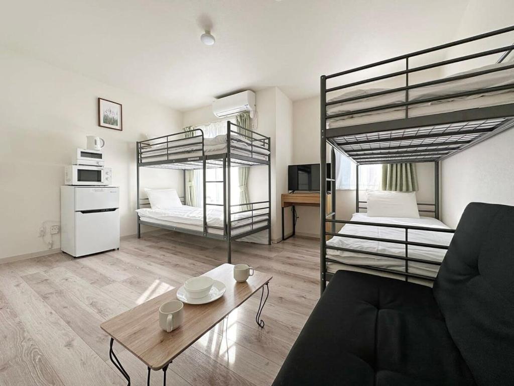 a living room with two bunk beds and a table at bHOTEL Yutori - Attractive 1Br Apt for 4 people in Onomichi in Onomichi