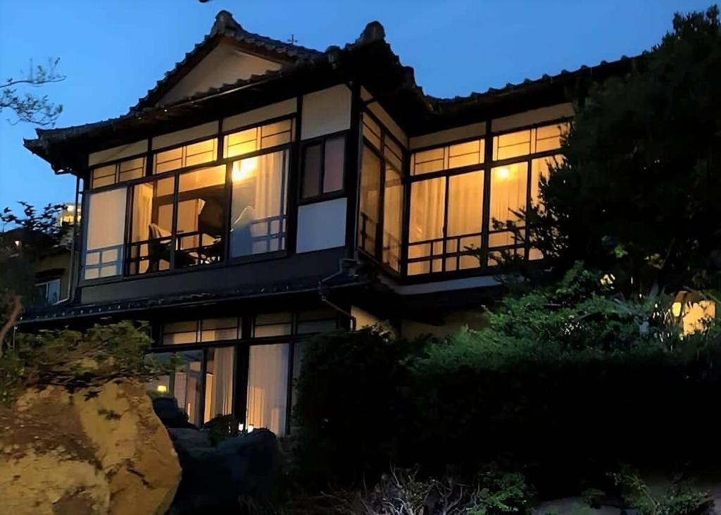 Casa grande con ventanas grandes por la noche en bLOCAL Bingo Yamamo - Experience at Traditional Japanese House, en Onomichi