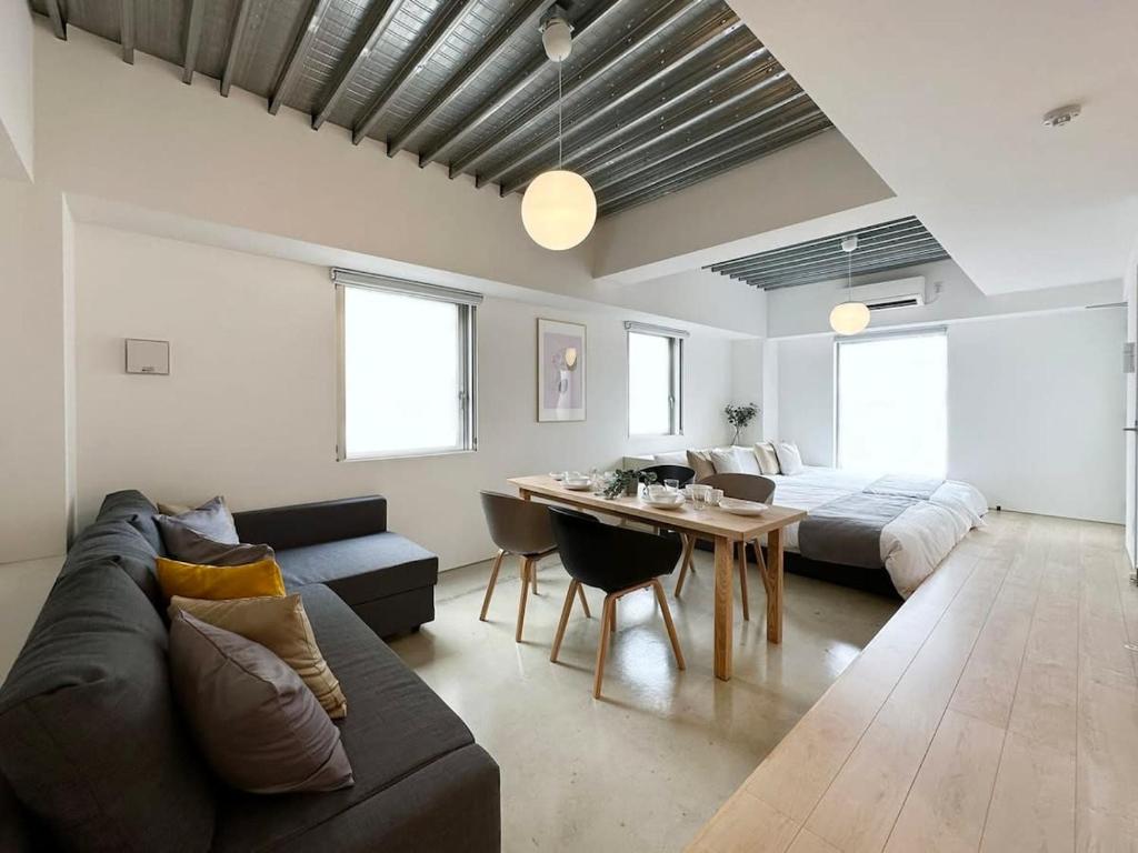 a living room with a couch and a table at bHOTEL Arts Dobashi - Studio Apt for 6 Ppl Near Peace Park in Hiroshima