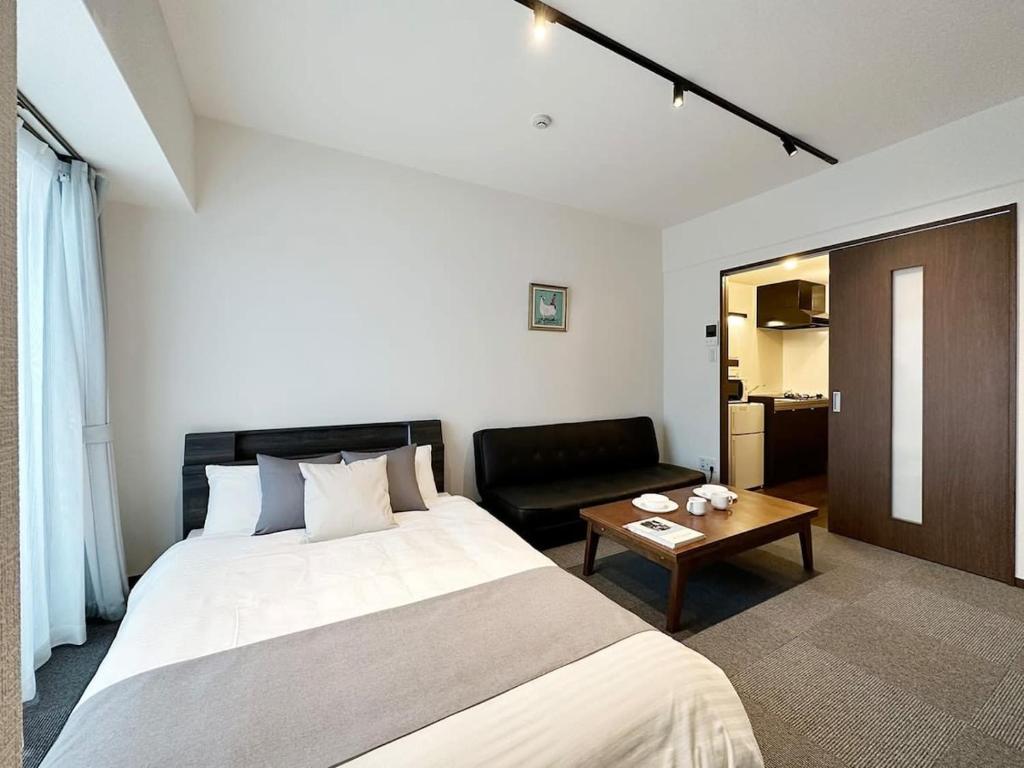 een hotelkamer met een bed en een salontafel bij bHOTEL Nagomi - Cozy 1BR Apartment with Balcony for 3Ppl in Hiroshima