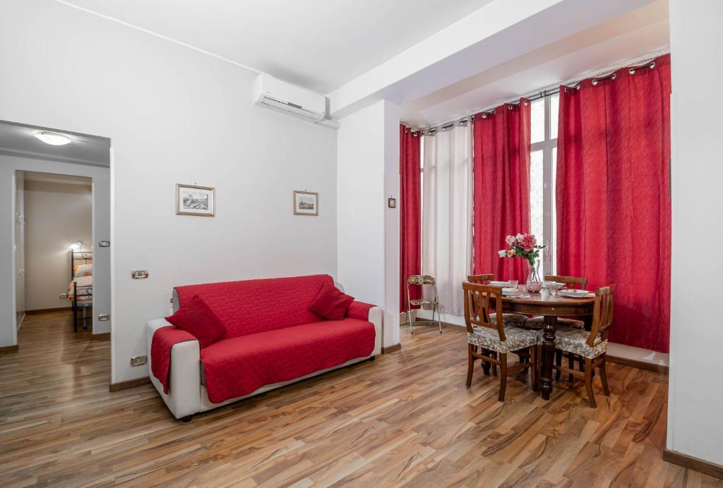 a living room with a red couch and a table at House Serena in Rome
