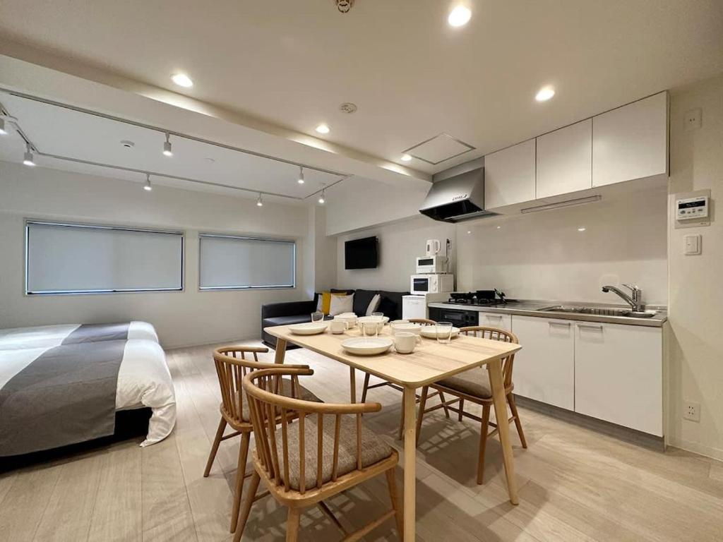 a room with a kitchen and a table and a bed at bHOTEL F-style - Cozy New Apt in the Heart of the City in Hiroshima