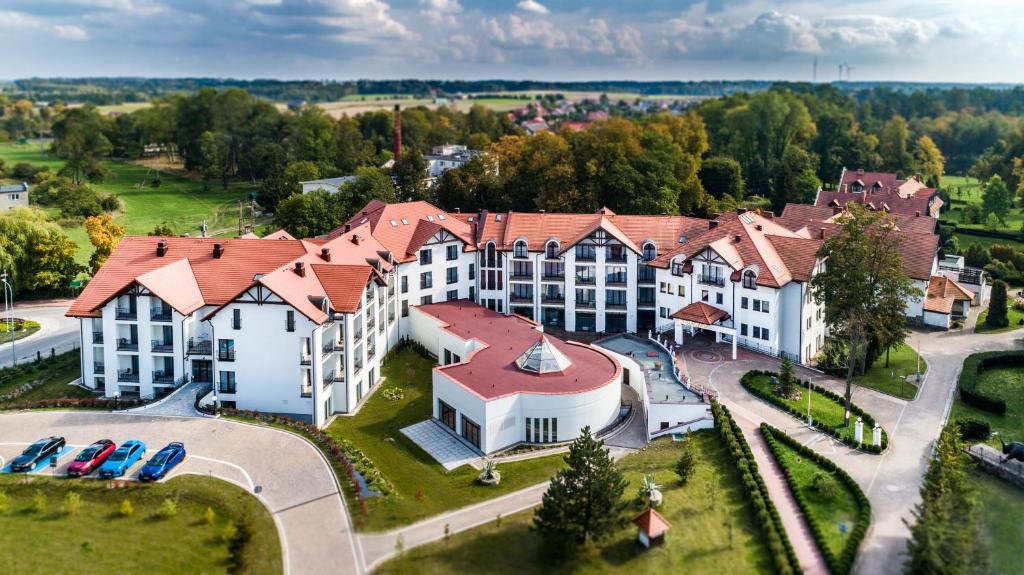 eine Luftaufnahme eines großen Gebäudes mit davor geparkten Autos in der Unterkunft Medica Hotel Krojanty Bory Tucholskie in Chojnice