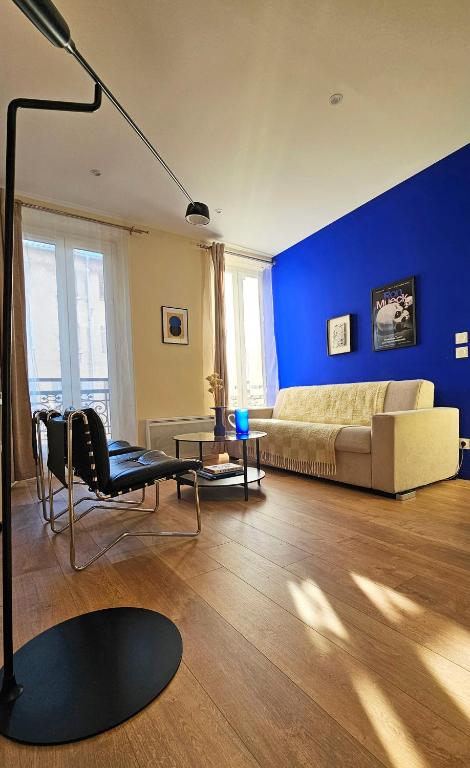 une chambre avec un lit et un mur bleu dans l'établissement La Grande Bleue - Appartement confortable à deux pas du Panier, à Marseille