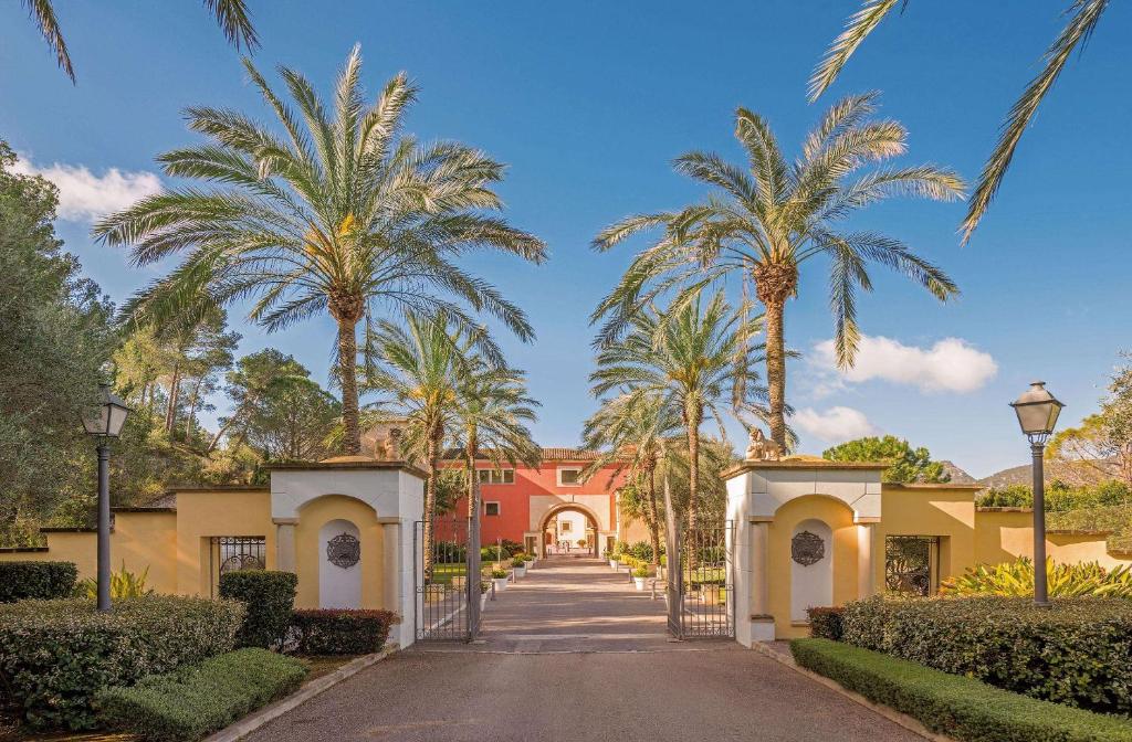 a driveway leading to a house with palm trees at Steigenberger Hotel and Resort Camp de Mar in Camp de Mar