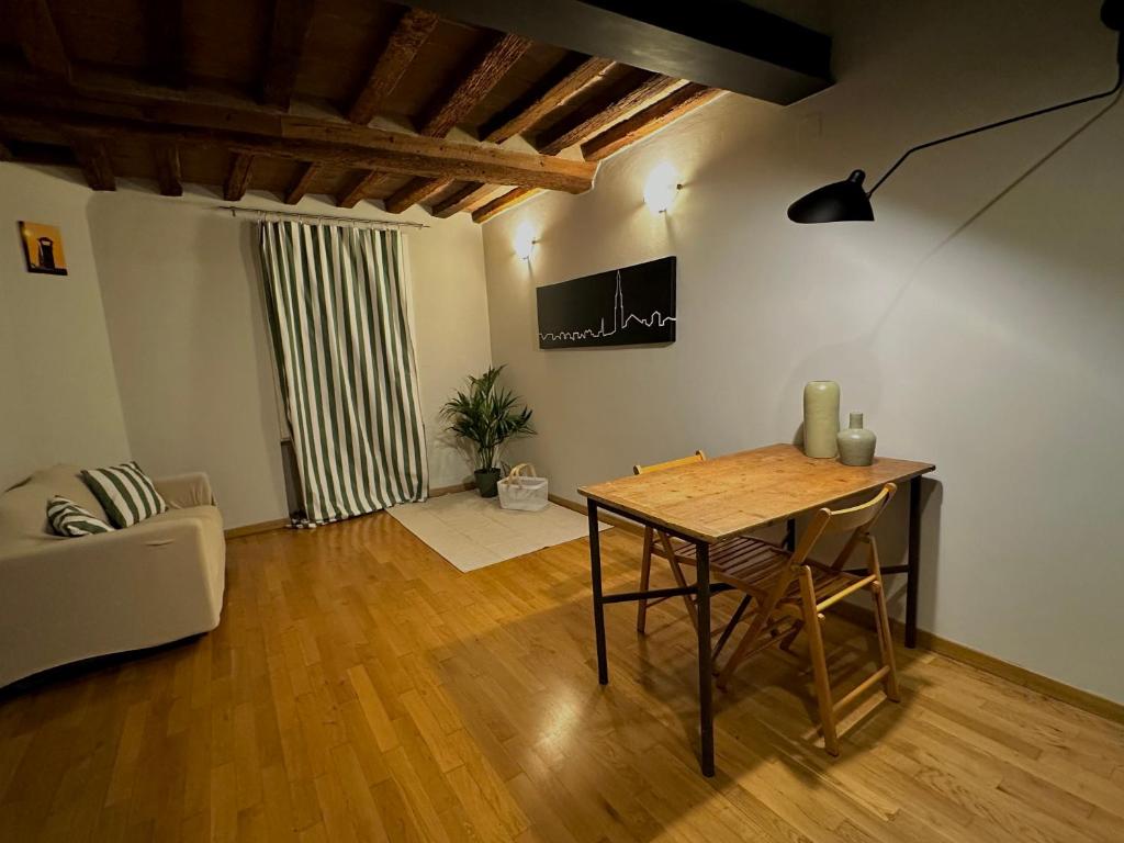 a living room with a table and a couch at Maison Vert appartamento in centro storico a Modena in Modena