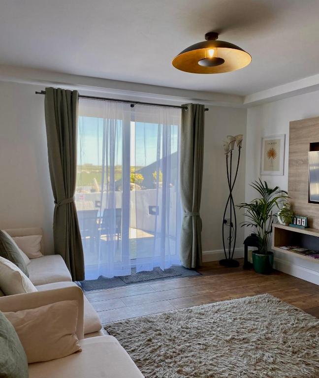 uma sala de estar com um sofá e uma grande janela em The Meadows Hideaway em Doolin